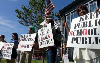 image: educators and supporters of public education with signs